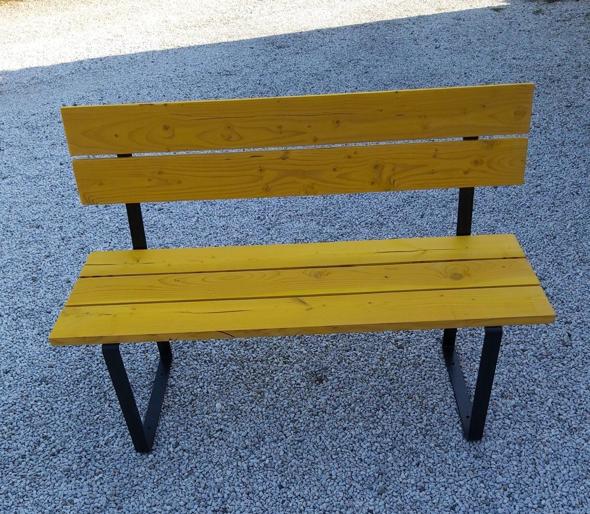Banc en bois avec lasure jaune et métal  Banc en bois avec lasure jauneet ça base en metal peint noir